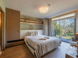 Step into a serene bedroom retreat, featuring a cozy bed adorned with soft linens and a stylish throw blanket.