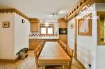 This charming kitchen features a warm, inviting atmosphere with its wooden cabinetry and dining table.