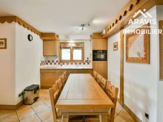 This charming kitchen features a warm, inviting atmosphere with its wooden cabinetry and dining table.