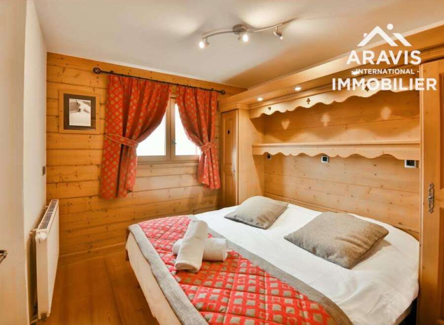Discover the charm of this cozy bedroom, featuring warm wooden accents and a comfortable bed.