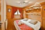 Discover the charm of this cozy bedroom, featuring warm wooden accents and a comfortable bed.