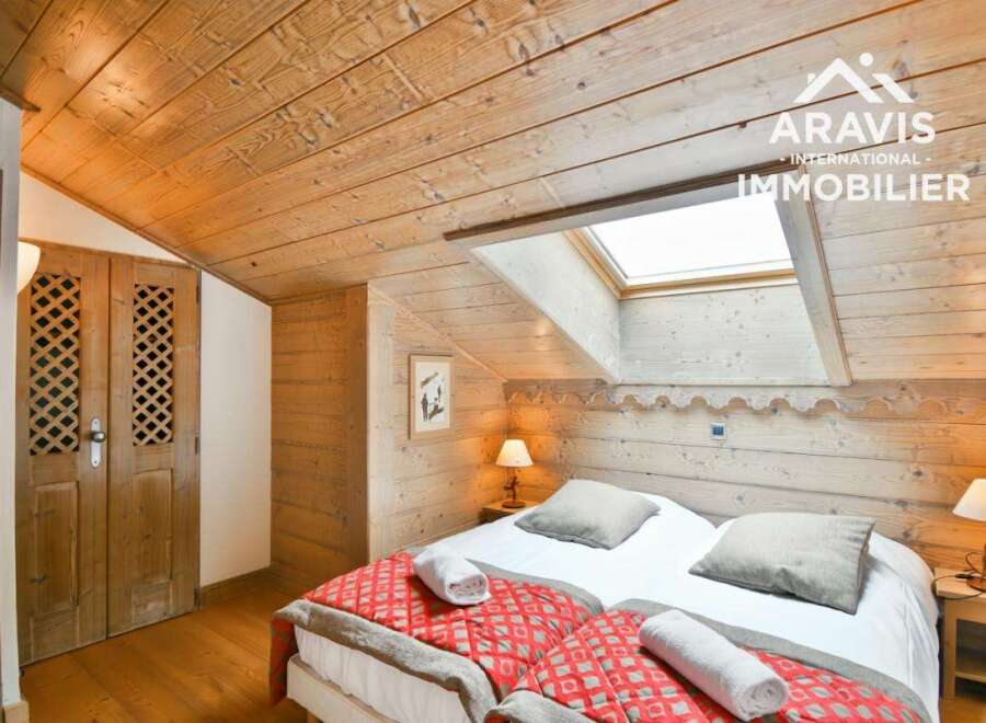 Discover the charm of this cozy bedroom featuring a unique wooden ceiling and walls, creating a warm and inviting atmosphere.