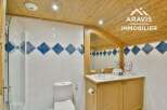 Discover this charming bathroom featuring a unique design with wooden accents and a stylish tiled wall.