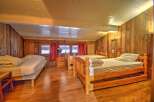 This cozy bedroom features wooden walls and floors, creating a warm and inviting atmosphere.