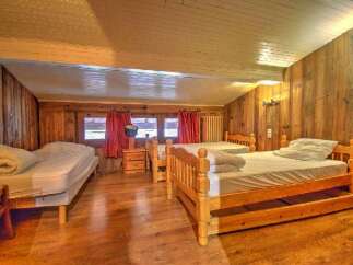 This cozy bedroom features wooden walls and floors, creating a warm and inviting atmosphere.