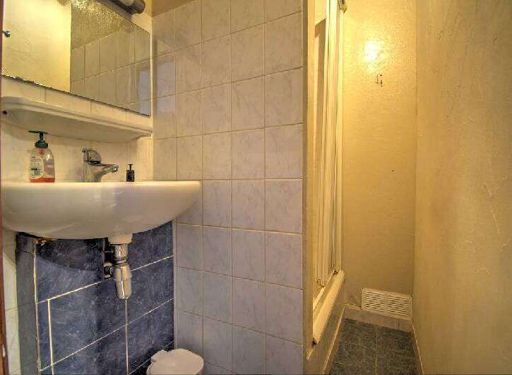 Discover this charming bathroom featuring a pristine white sink and a convenient shower area.