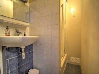 Discover this charming bathroom featuring a pristine white sink and a convenient shower area.