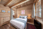 Experience the warmth and charm of this cozy bedroom, featuring beautiful wooden paneling and a comfortable bed.