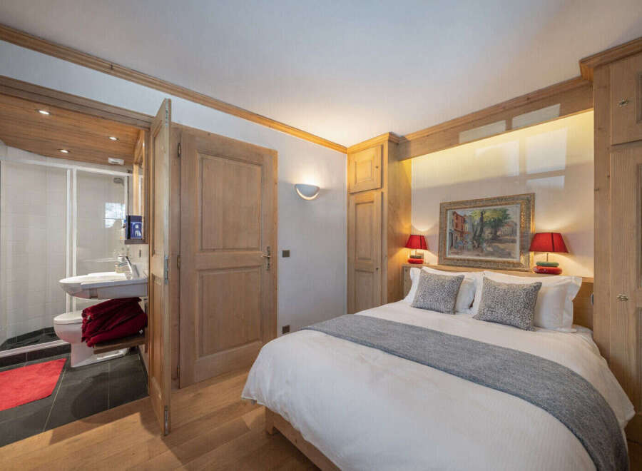 This charming bedroom features a cozy bed with plush pillows and a stylish gray throw, perfect for a relaxing retreat.