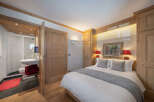 This charming bedroom features a cozy bed with plush pillows and a stylish gray throw, perfect for a relaxing retreat.