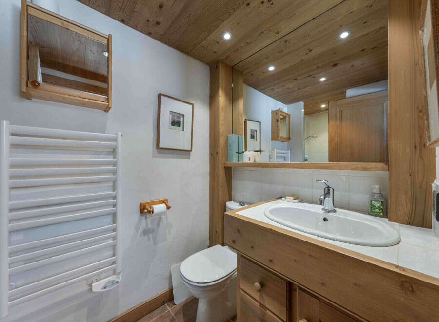 This charming bathroom features a rustic wooden vanity and a sleek, modern sink.