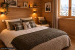 Experience cozy mountain living in this charming bedroom, featuring warm wood paneling and a plush bed adorned with rustic plaid pillows.