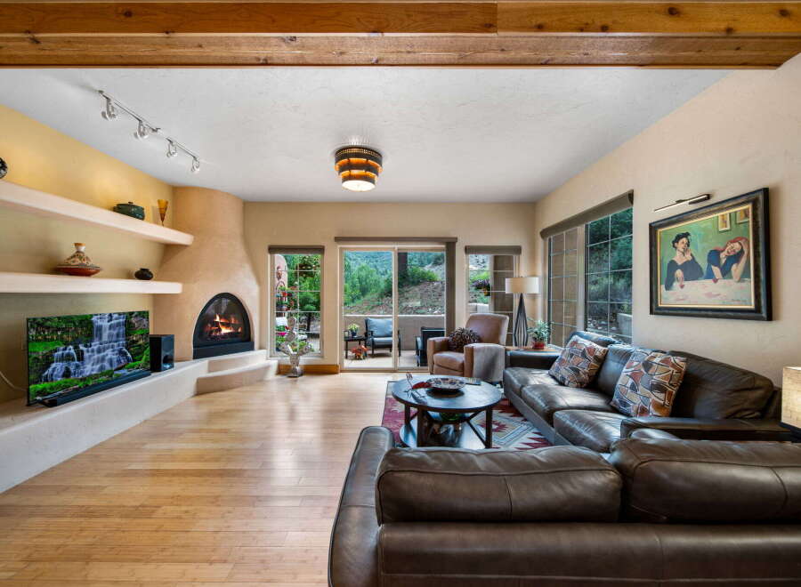 Step into luxury with this stunning living room, featuring a cozy fireplace and a large flat-screen TV.