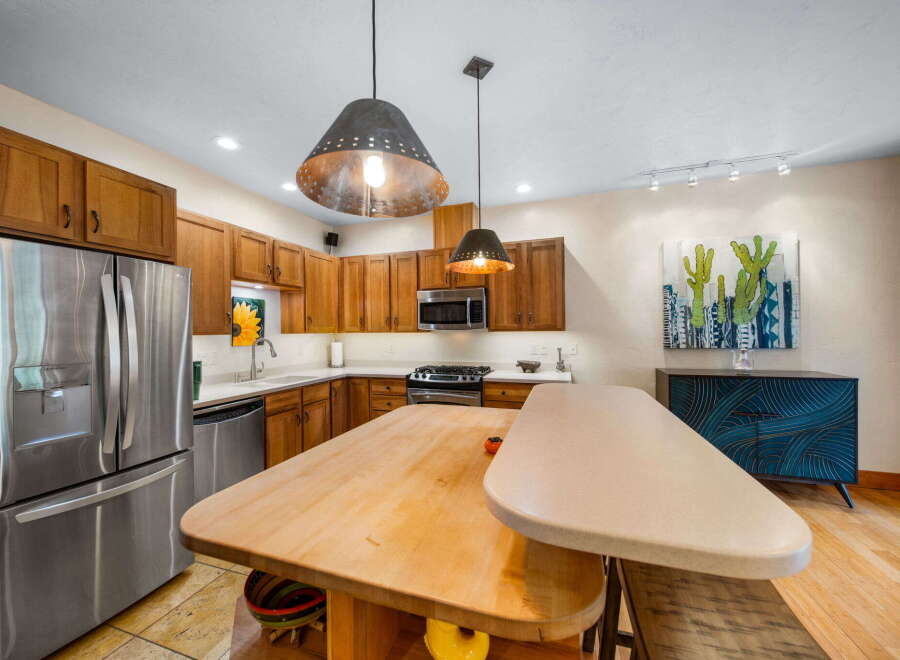 This stunning kitchen boasts beautiful wooden cabinetry and stainless steel appliances, creating a warm and inviting atmosphere.