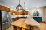 This stunning kitchen boasts beautiful wooden cabinetry and stainless steel appliances, creating a warm and inviting atmosphere.