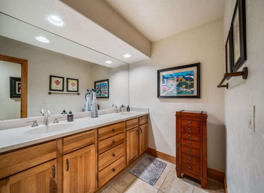 This stunning bathroom features a large mirror, double sinks, and ample cabinet space, perfect for a luxurious and functional space.