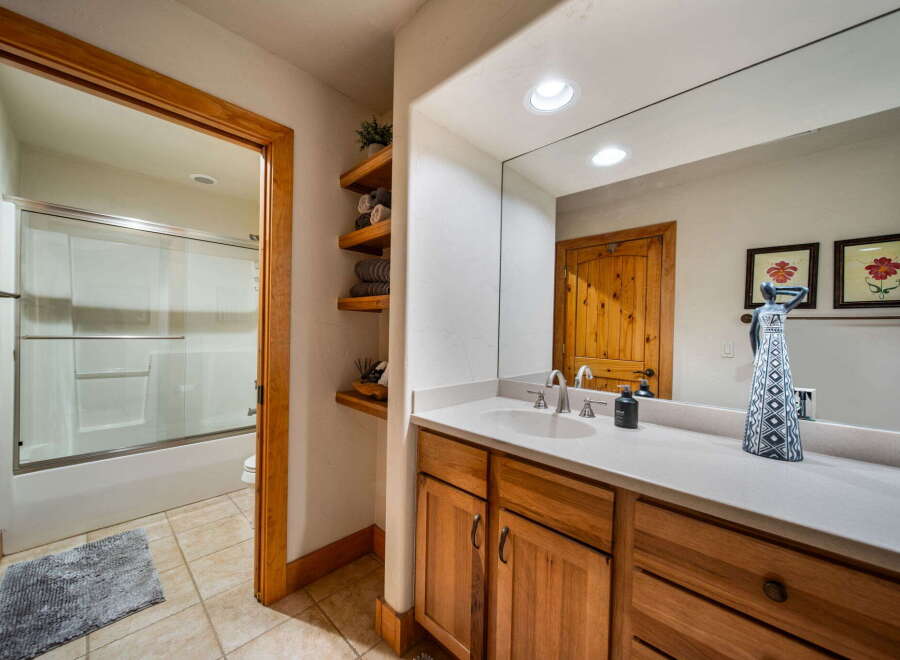 This charming bathroom features a warm, inviting design with natural wood cabinetry and a bright, spacious feel.