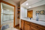This charming bathroom features a warm, inviting design with natural wood cabinetry and a bright, spacious feel.