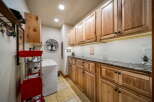 Step into this beautifully designed laundry room, featuring custom wooden cabinetry that offers ample storage space.