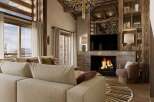 Experience luxury living in this stunning property, featuring a cozy fireplace and a modern entertainment setup.