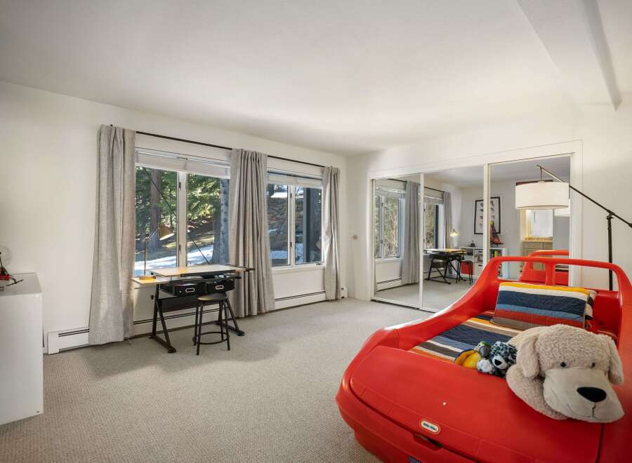 This charming bedroom features a unique red car-shaped bed, perfect for a child's room.