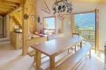 Experience the charm of this rustic chalet, featuring a spacious dining area with a large wooden table and benches, perfect for gatherings.