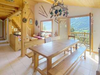 Experience the charm of this rustic chalet, featuring a spacious dining area with a large wooden table and benches, perfect for gatherings.