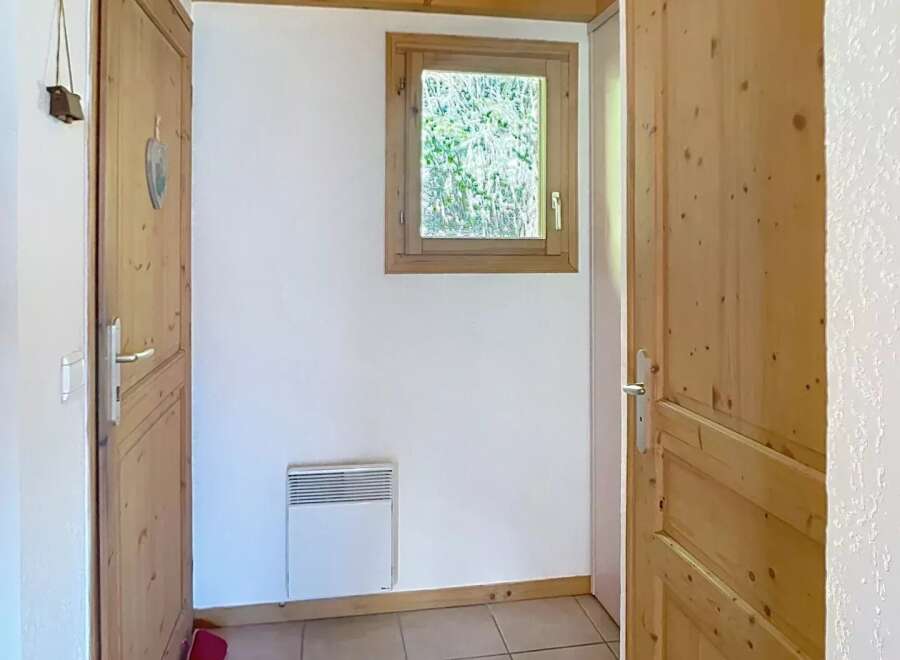 Step into this charming entryway, featuring warm wooden doors and a cozy ambiance.