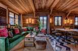 Step into luxury with this stunning property, showcasing a cozy living room with a plush green velvet sofa and a unique wooden ceiling.
