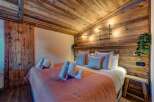 Experience rustic charm in this cozy bedroom, featuring a stunning wooden ceiling and accent wall.