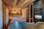 Experience rustic luxury in this stunning bedroom featuring a unique wooden ceiling and walls.