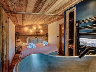 Experience rustic luxury in this stunning bedroom featuring a unique wooden ceiling and walls.