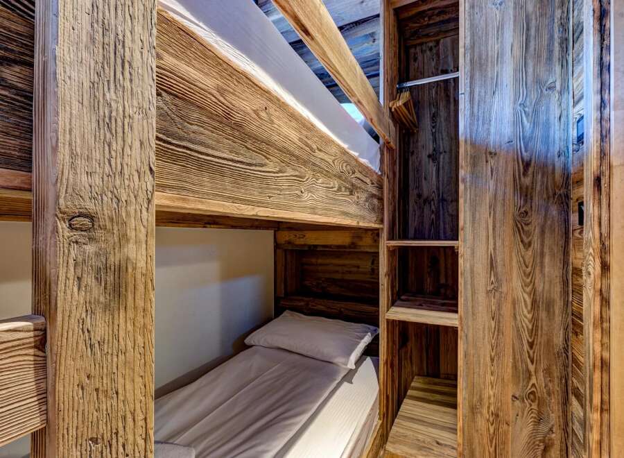 Discover the charm of this cozy bunk bed setup, perfect for maximizing space in a vacation home or rental property.