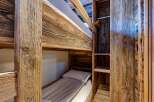 Discover the charm of this cozy bunk bed setup, perfect for maximizing space in a vacation home or rental property.