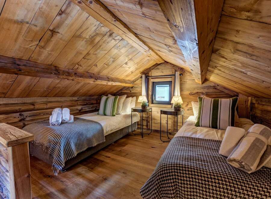 Discover the charm of this cozy bedroom, featuring rustic wooden accents and a warm, inviting atmosphere.