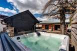Relax and unwind in this luxurious property featuring a private hot tub, perfect for enjoying the serene surroundings.