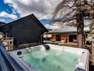 Relax and unwind in this luxurious property featuring a private hot tub, perfect for enjoying the serene surroundings.