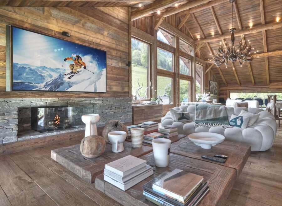 Experience luxury living in this stunning chalet, featuring a cozy fireplace and a large flat-screen TV perfect for relaxing after a day on the slopes.