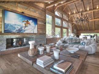 Experience luxury living in this stunning chalet, featuring a cozy fireplace and a large flat-screen TV perfect for relaxing after a day on the slopes.
