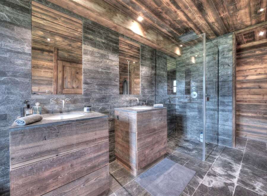 Experience luxury in this stunning bathroom featuring a rustic wooden vanity and sleek stone accents.