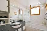 Discover this charming bathroom featuring a sleek vanity with a modern sink and ample storage.