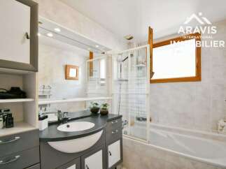 Discover this charming bathroom featuring a sleek vanity with a modern sink and ample storage.