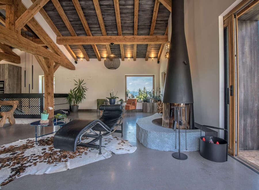 Experience luxury living in this stunning property featuring a modern fireplace and exposed wooden beams.
