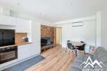 Discover this modern apartment featuring a stylish kitchen with sleek white cabinetry and a built-in oven.