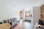 Discover this charming property featuring a cozy living space with a comfortable sofa and a dining area.