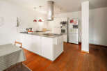 This modern kitchen boasts sleek white cabinetry and a spacious island, perfect for culinary enthusiasts.