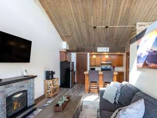 Step into this cozy living space, featuring a stunning stone fireplace and a modern entertainment setup.