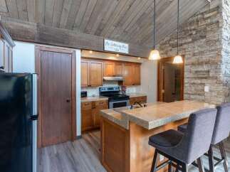 Step into this stunning kitchen, featuring a beautiful stone accent wall and a cozy breakfast bar.