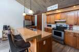 This stunning kitchen boasts a modern design with beautiful wooden cabinetry and a spacious granite countertop island, perfect for entertaining.