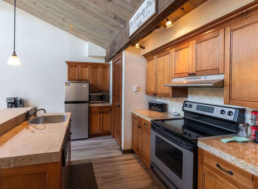 This charming kitchen boasts beautiful wooden cabinetry and a modern stainless steel appliance package.